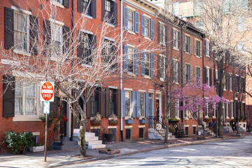 Rows of brownstone apartment buildings in Center City with windows, stoops and planters in...