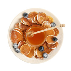 Delicious mini pancakes cereal with blueberries and honey on white background, top view