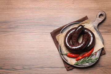 Tasty blood sausages served on wooden, top view. Space for text