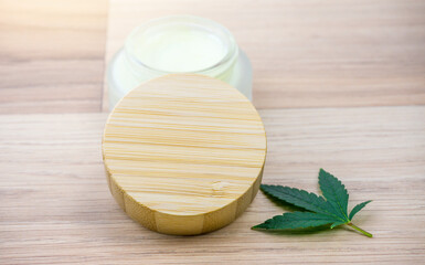 Cannabis CBD lotion in glass container with Cannabis leaf and copy space on lid