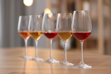 Different sorts of wine in glasses prepared for tasting on wooden table indoors