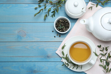 Aromatic eucalyptus tea on light blue wooden table, flat lay. Space for text