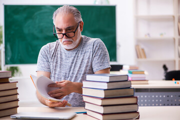 Old male student preparing for exams in the classroom