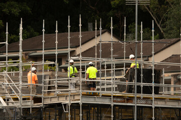 Worker assembling floor formwork on new social housing home unit block at 56-58 Beane St. Gosford, Australia. March 11, 2021. Part of a series.