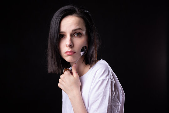 woman in white t-shirt holding a tablespoon