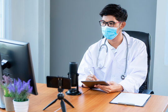 New normal, medical team wearing medical masks technology network team meeting concept. Doctor at a table discussing a patients records working, Online medical