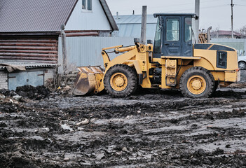 Fototapeta na wymiar Excavator tractor with bucket working in mud, preparation for construction