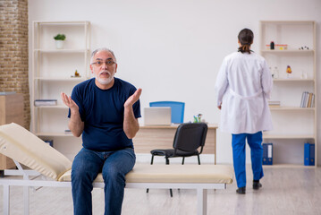 Fototapeta premium Old male patient visiting young male doctor