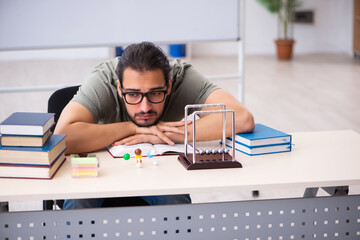 Young male student preparing for exams in the classroom