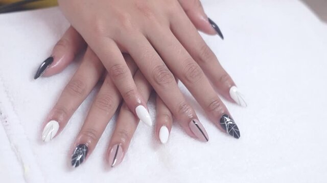 Women paints nails.Manicure Nail Art close up. Beautiful Nail Art Manicure. Nail designs with decoration.Manicure nail paint.