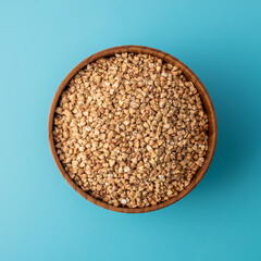 Bowl of green buckwheat on a blue background. Concept of a balanced diet and healthy food. Top view