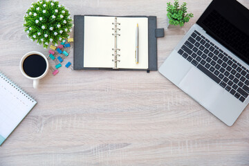 Top view desk with computer or laptop with a pen and a book and office equipment for work area copy space and work from home or education school background concepts.