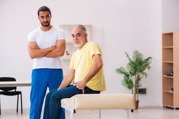 Old male patient visiting young male doctor chiropractor