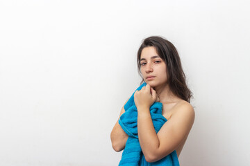 Woman wrapped in blue towel on white background