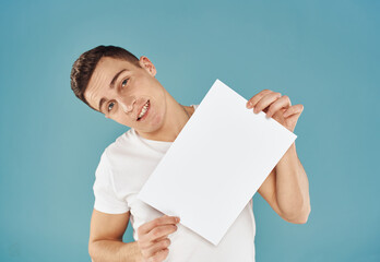 Handsome guy with white sheet of paper advertising mockup Copy Space