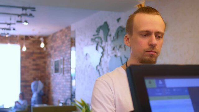 A restaurant visitor stands at the checkout. The cashier gives the acquiring terminal to the visitor, he pays for the restaurant's services, uses the NSF payment. Small business. Close-up.
