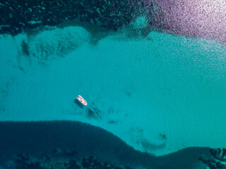 Aerial view of small boat in turquoise Mediterranean