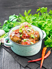 Meatballs in sweet and sour sauce on wooden board