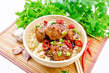 Meatballs in sweet and sour sauce with rice on bamboo napkin