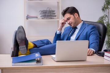 Young male employee being unhappy with excessive work