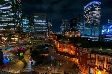 黄昏時、ライトアップされた東京駅と周囲の高層ビル群
