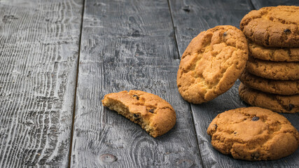 Fresh homemade cookies with chocolate chips on a wooden table.