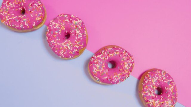 Donas glaseadas color rosado con chispas o lluvia de colores fondo bicolor 11