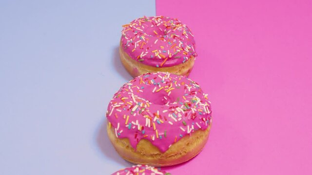 Donas glaseadas color rosado con chispas o lluvia de colores fondo bicolor 10