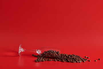 a glass and coffee beans on a red background 