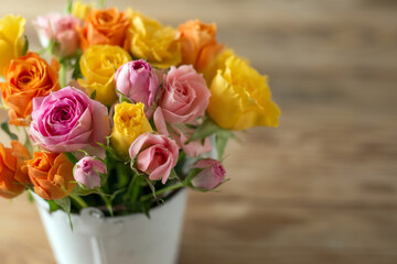 Beautiful pink, orenge and yellow roses flowers on old wooden table