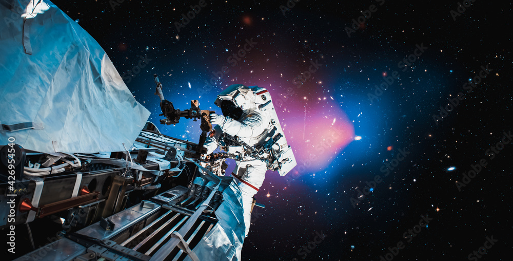 Wall mural astronaut spaceman do spacewalk while working for space station in outer space . astronaut wear full
