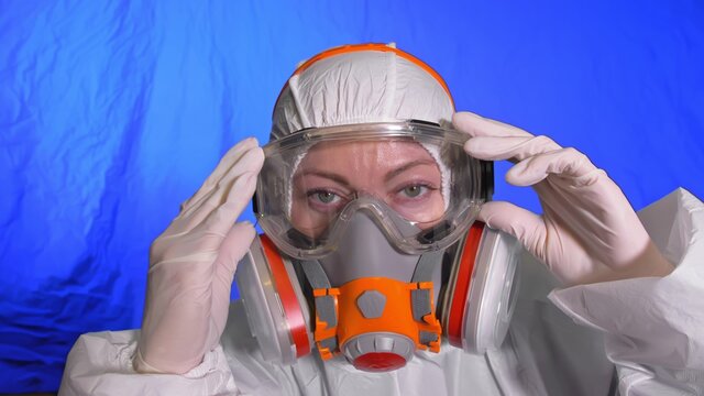 Scientist virologist in respirator. Woman close up look, wearing protective medical mask. Concept health safety N1H1 coronavirus epidemic 2019 nCoV.