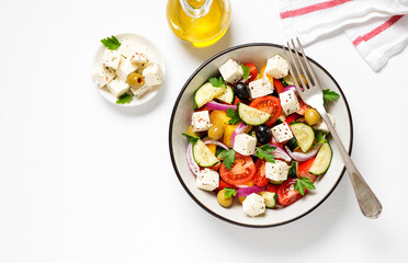 Classic Greek salad with fresh vegetables, feta cheese and olives. Healthy food. White background. Top view	