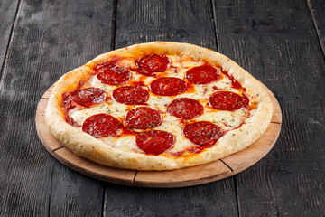Fresh baked pepeproni pizza on the wooden background