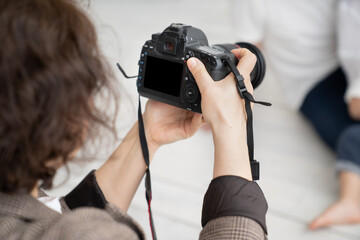 A brunette woman working photographer. photo shoot in a photo studio. backstage 