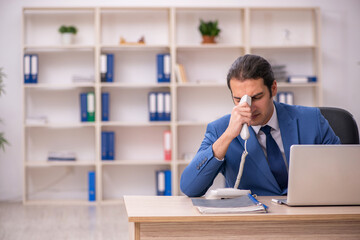 Young male employee sitting in the office