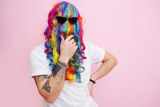 Hilarious looking man in a wig over face and sunglasses stroking beard.