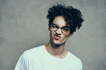 funny curly guy in a white t-shirt glasses emotions studio fashion