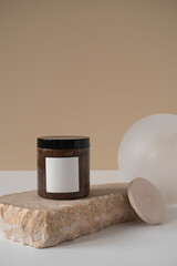 Aesthetic minimalist beauty care therapy concept. Blank body care cream jar on marble stone against neutral beige background. Organic natural body skin treatment product composition