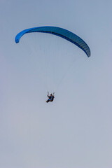 Paraglider flying high up in the sky