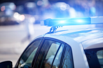 Obraz na płótnie Canvas Police car with blue lights on the crime scene in traffic urban environment.