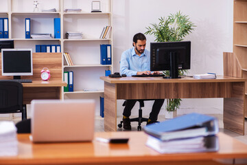 Naklejka premium Young male employee working in the office