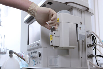 The anesthesiologist prepares the equipment for surgery under general anesthesia. Container for medicines. Drug for anesthesia. Beyond recognition. Close-up. Artificial lung ventilation apparatus.