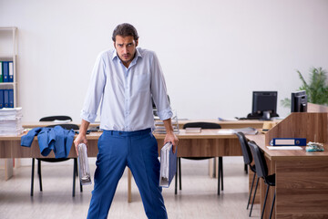 Young male employee doing sport exercises during break