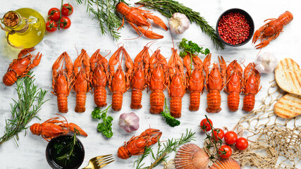 Seafood banner. Red boiled crawfishes on table in rustic style, on a white wooden background. Top view. Flat lay.