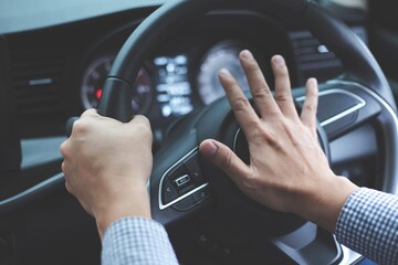 Close up image of inside the car of the hand pressing the horn on the steering wheel.Safe driving concept - obrazy, fototapety, plakaty