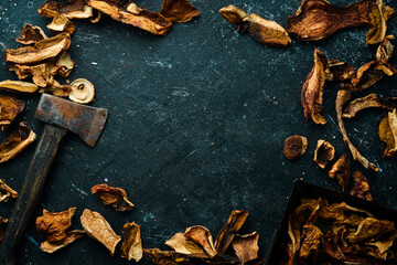 dried wild organic porcini mushroom on a black stone background. Autumn food. Top view. Free space for text.
