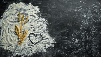 Wheat flour. Bakery on a black stone background. Top view. Free space for text.
