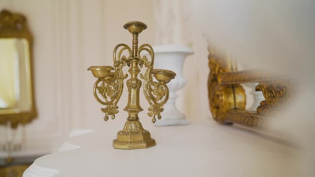 Classic bronze candlestick. One antique candlestick, bronze candle tree. Gold candlestick in a photo studio.