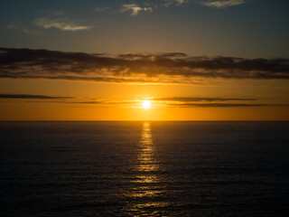 A beautiful golden sunset over the ocean horizon on a warm summers evening.